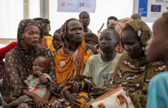 Seorang ibu mengais kacang di kamp pengungsian, menggambarkan perjuangan bertahan hidup di tengah krisis kemanusiaan Sudan Selatan yang semakin memburuk akibat konflik bersenjata dan terhambatnya bantuan, Source: EU/EEA Regulatory Notice