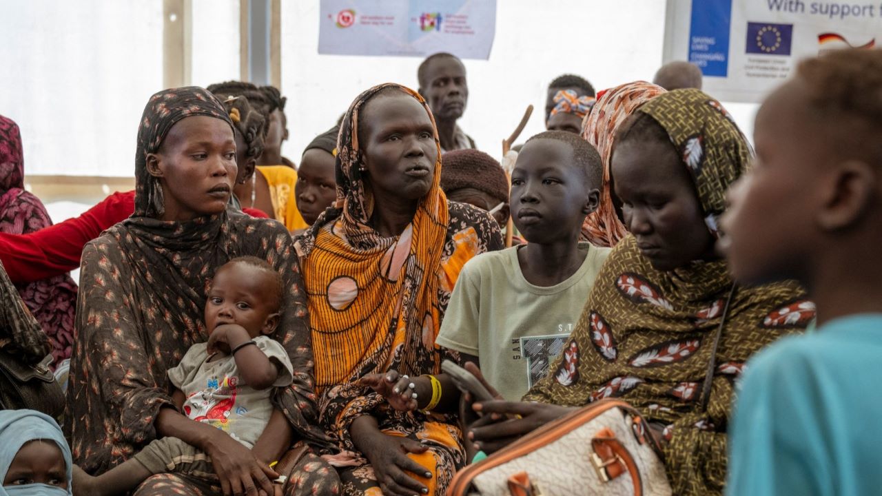 Seorang ibu mengais kacang di kamp pengungsian, menggambarkan perjuangan bertahan hidup di tengah krisis kemanusiaan Sudan Selatan yang semakin memburuk akibat konflik bersenjata dan terhambatnya bantuan, Source: EU/EEA Regulatory Notice
